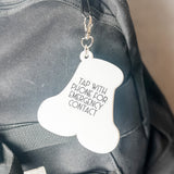 Keychain with emergency contact information attached to a backpack