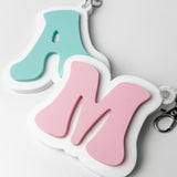 Two keychains with letters 'A' and 'M' on a white background
